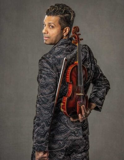 G Pinto - brown suit - with back turned holding violin